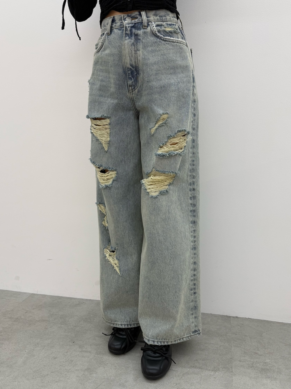 ブラック系のブルゾン、ホワイト系のTシャツ/カットソー、ブルー系のデニムパンツを着用したレディースの冬コーディネートの7枚目の写真