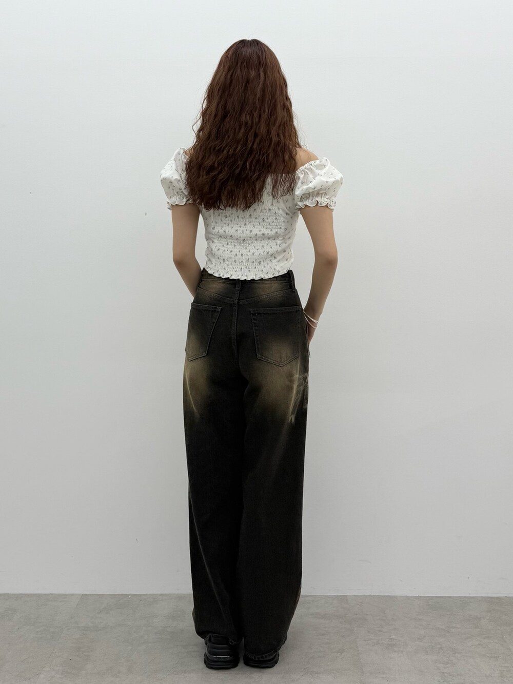 ブラック系のデニムパンツ、ブラック系のサンダル、シルバー系のネックレスを着用したレディースの夏コーディネートの3枚目の写真