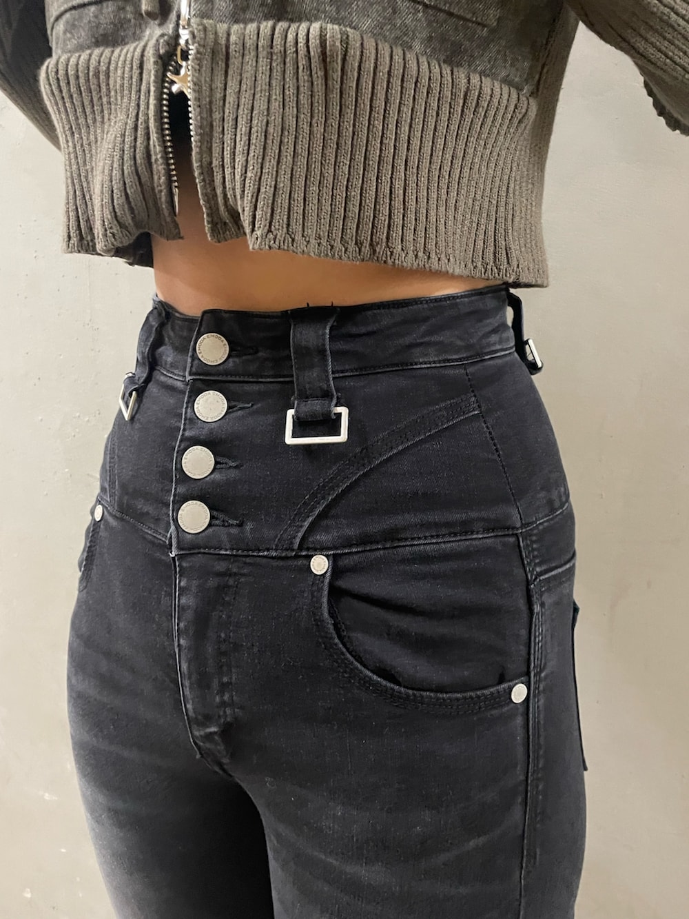 グリーン系のニット/セーター、ブラック系のデニムパンツ、ブラック系のサンダルを着用したレディースの春コーディネートの9枚目の写真