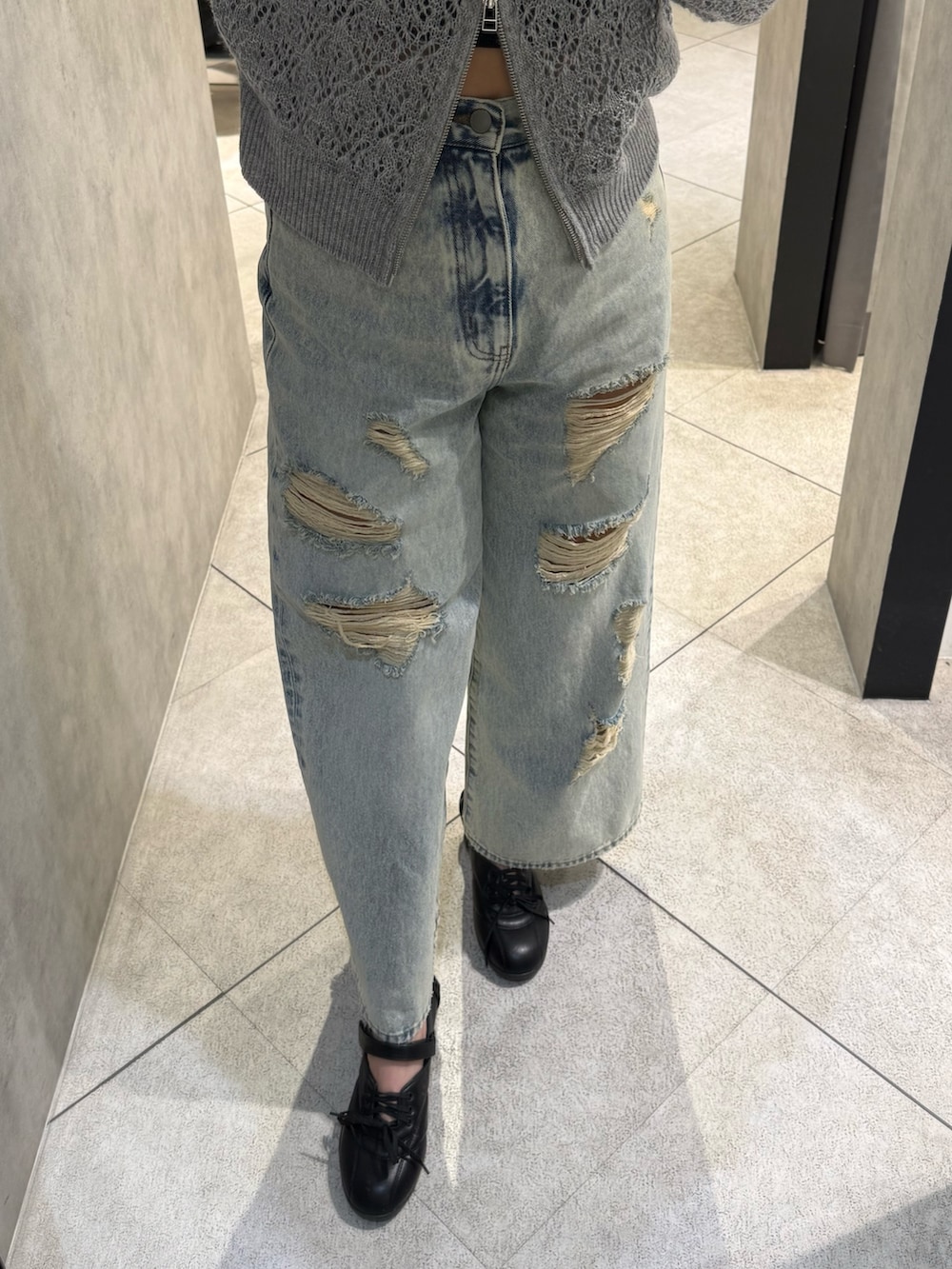 ブラック系のスニーカー、ブルー系のデニムパンツ、グレー系のパーカーを着用したレディースの春コーディネートの5枚目の写真