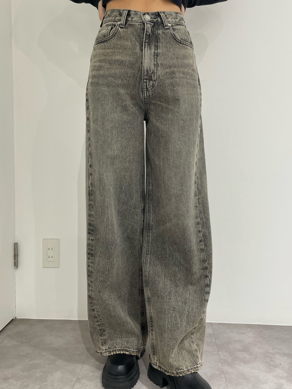 ブラック系のニット/セーター、グレー系のデニムパンツ、ブラック系のブーツを着用したレディースの春コーディネートの7枚目の写真