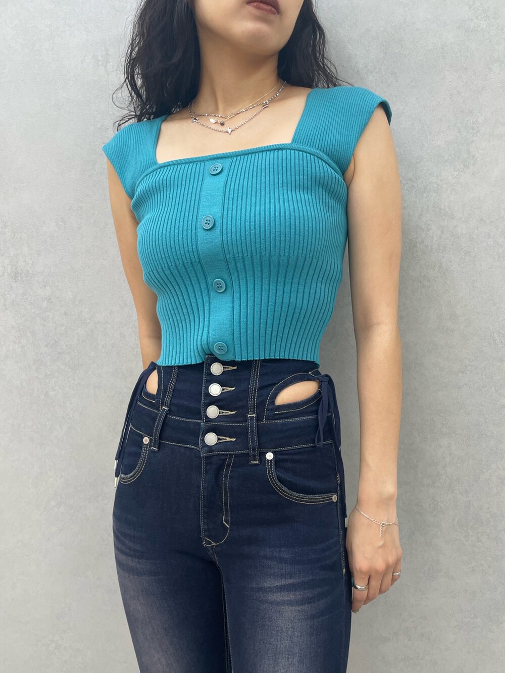 ブルー系のデニムパンツ、ブラック系のブーツ、シルバー系のネックレスを着用したレディースの夏コーディネートの4枚目の写真