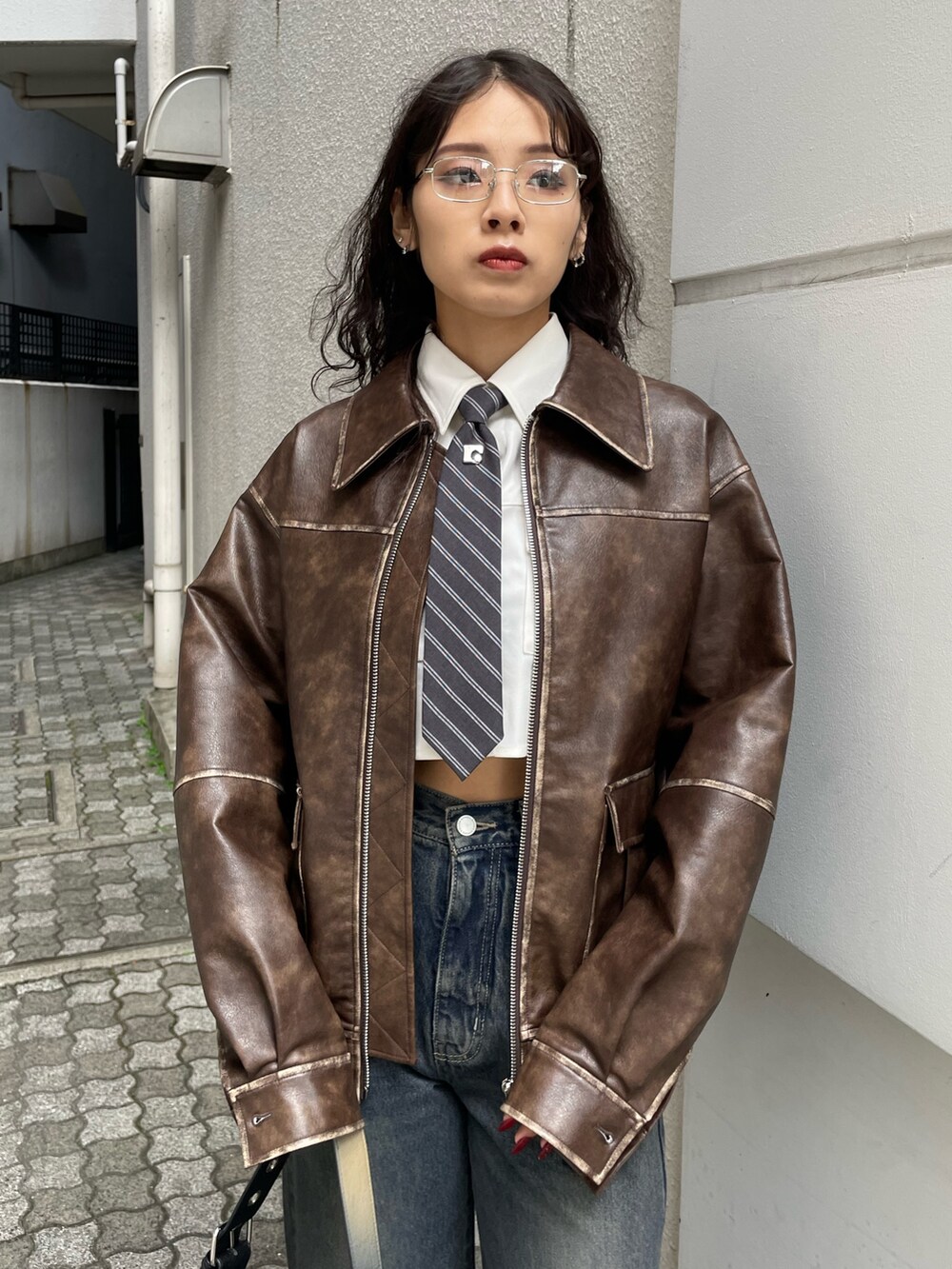 ホワイト系のシャツ/ブラウス、ブラウン系のブルゾン、ブルー系のデニムパンツを着用したレディースの秋コーディネートの4枚目の写真