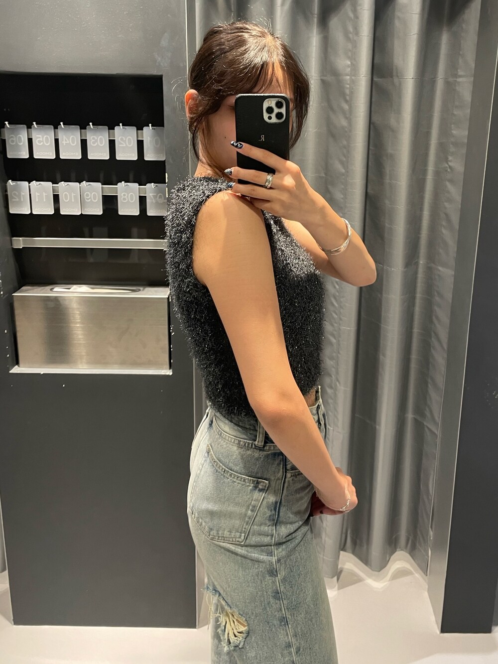 グレー系のタンクトップ、ブルー系のデニムパンツ、ブラック系のサンダルを着用したレディースの夏コーディネートの5枚目の写真