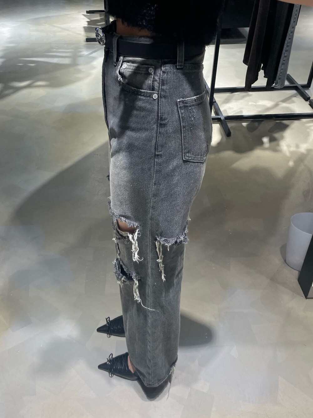 ブラック系のニット/セーター、ブラック系のデニムパンツ、ブラック系のパンプスを着用したレディースの春コーディネートの7枚目の写真