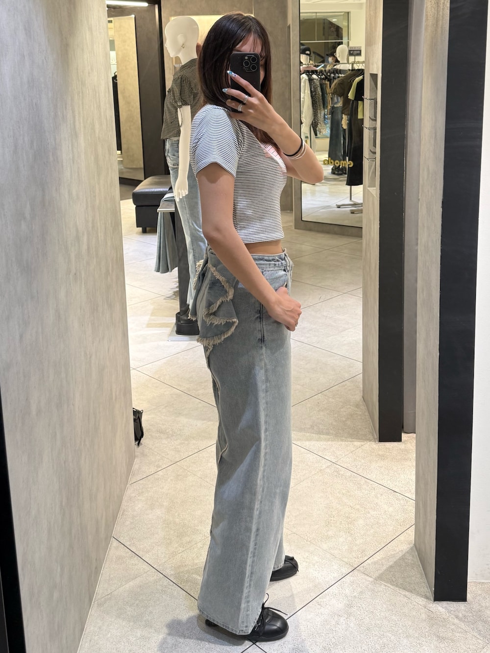 ホワイト系のTシャツ/カットソー、ブルー系のデニムパンツ、ブラック系のスニーカーを着用したレディースの春コーディネートの2枚目の写真