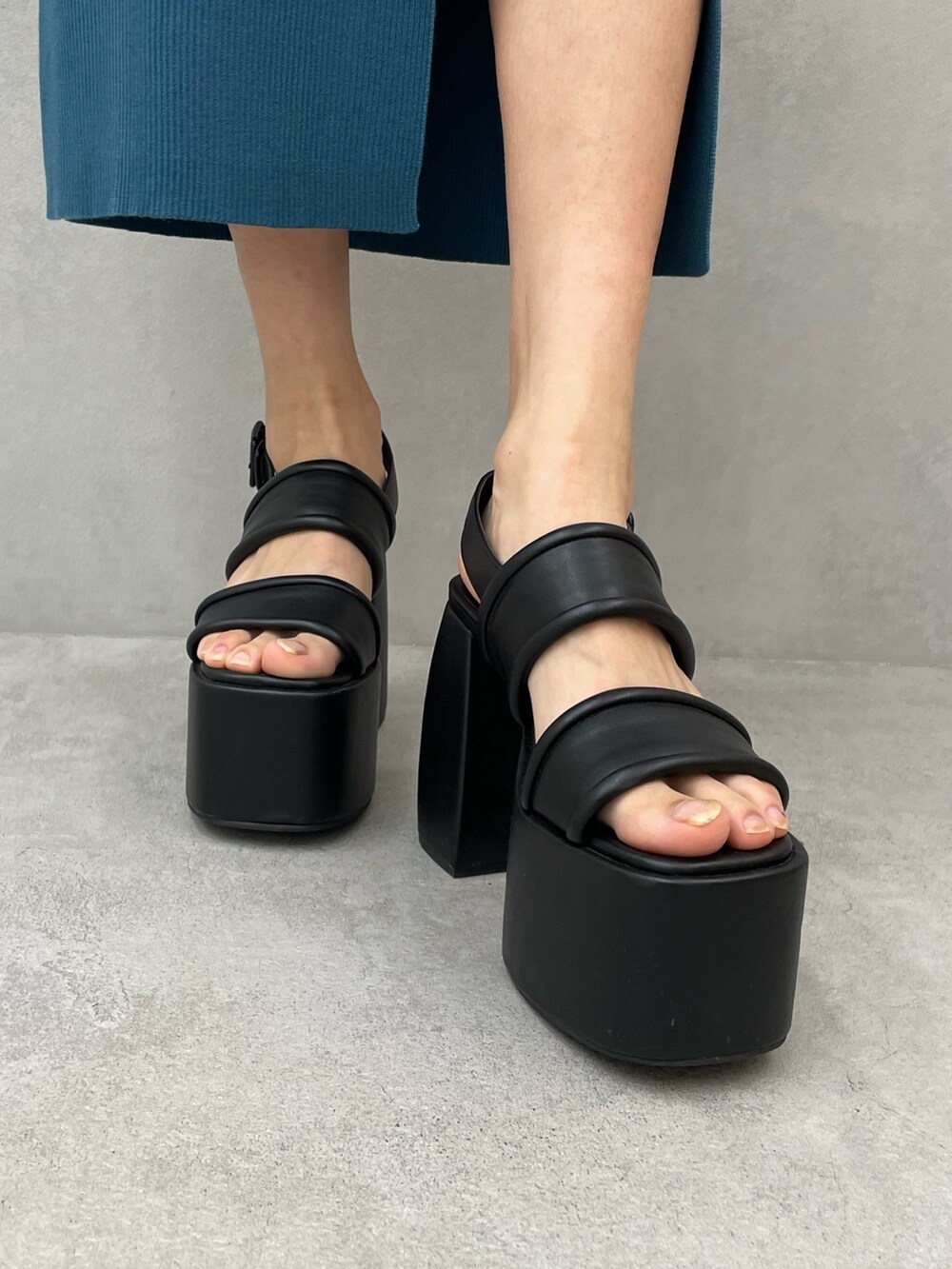 グレー系のTシャツ/カットソー、ブラック系のスカート、ブラック系のサンダルを着用したレディースの春コーディネートの8枚目の写真