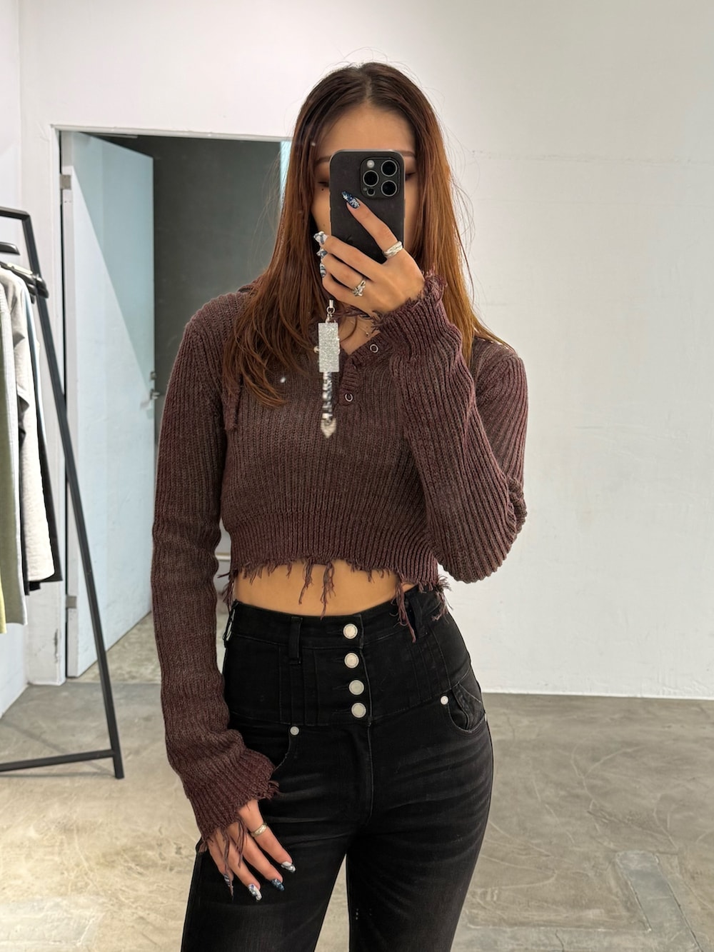 レッド系のニット/セーター、ブラック系のデニムパンツ、ブラック系のブーツを着用したレディースの冬コーディネートの4枚目の写真