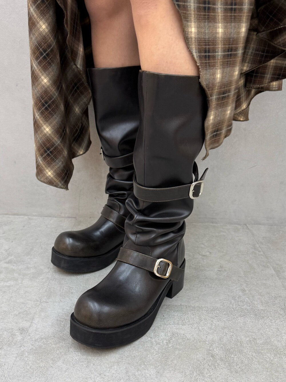 ブラック系のニット/セーター、ベージュ系のワンピース、ブラック系のブーツを着用したレディースの冬コーディネートの6枚目の写真