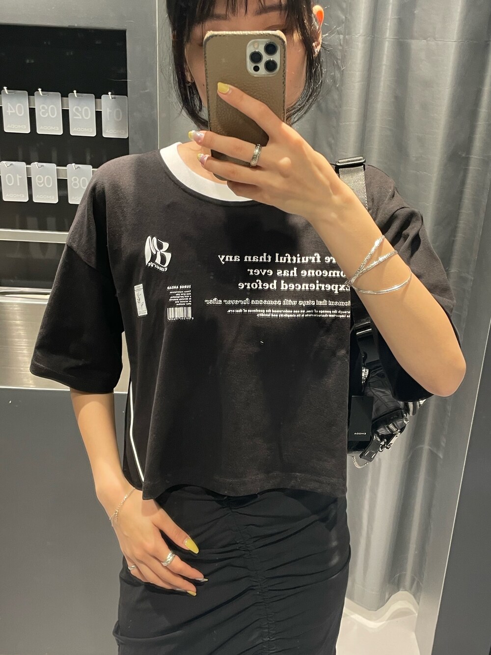 ブラック系のTシャツ/カットソー、ブラック系のハンドバッグ、ホワイト系のカーゴパンツを着用したレディースの春コーディネートの4枚目の写真