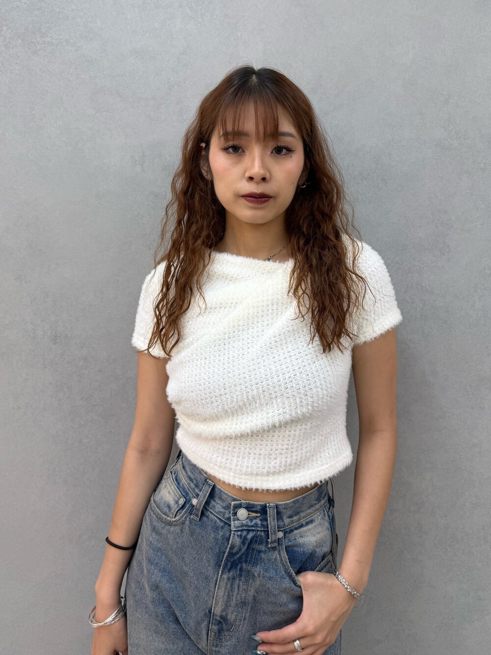 ホワイト系のTシャツ/カットソー、ブルー系のデニムパンツ、ブラック系のハンドバッグを着用したレディースの夏コーディネートの4枚目の写真