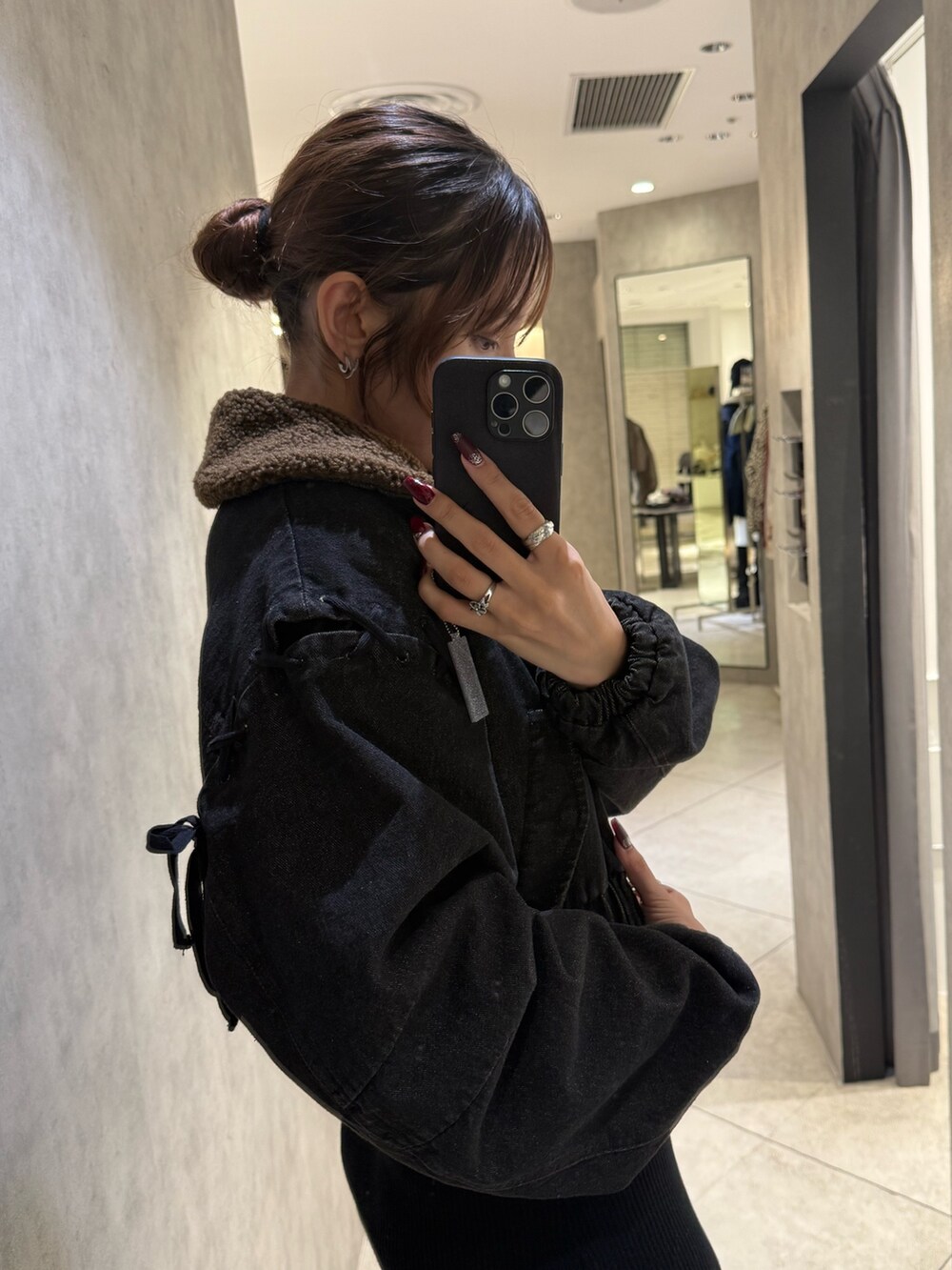 ブラック系のブルゾン、ブラック系のワンピース、ブラック系のブーツを着用したレディースの秋コーディネートの5枚目の写真