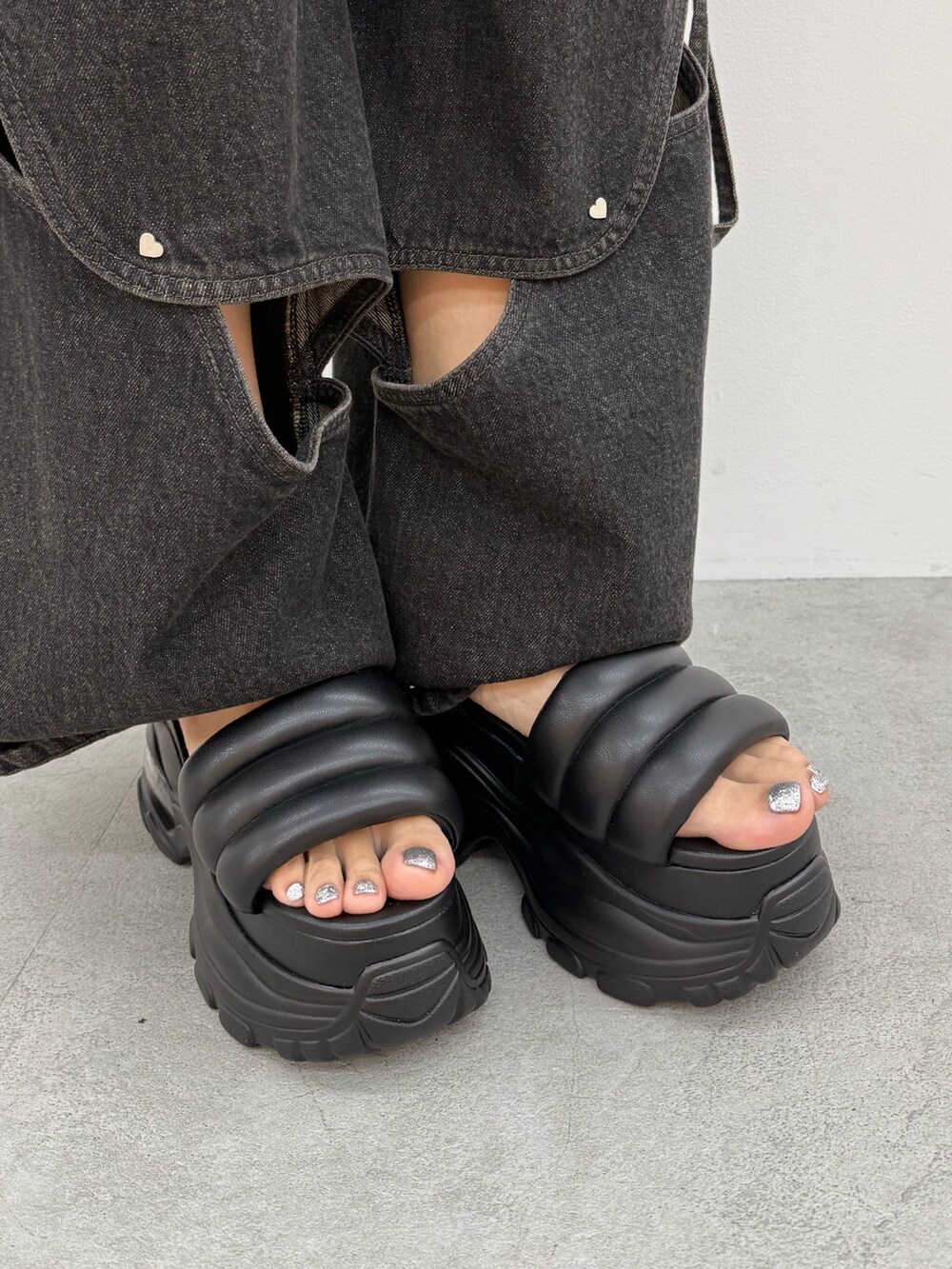 ブラック系のデニムパンツ、ブラック系のサンダル、シルバー系のネックレスを着用したレディースの夏コーディネートの10枚目の写真