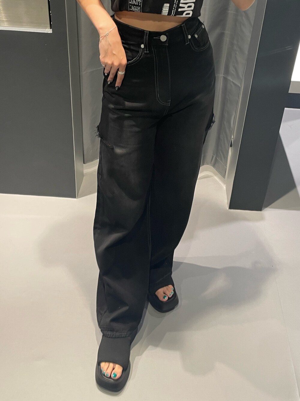 ブラック系のTシャツ/カットソー、ブラック系のデニムパンツ、ブラック系のサンダルを着用したレディースの夏コーディネートの6枚目の写真