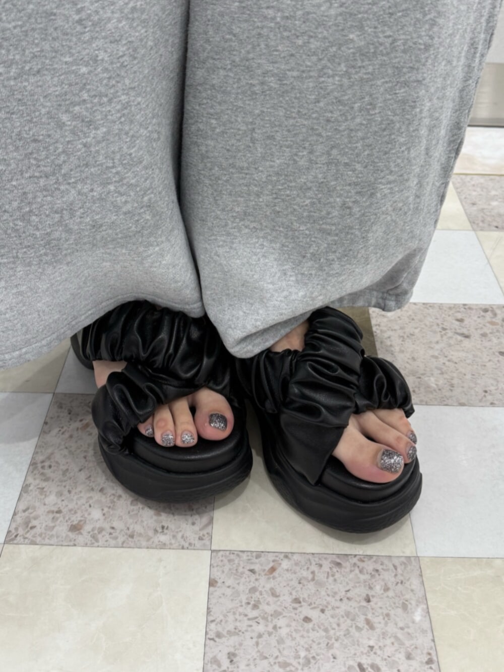 ブラック系のサンダル、グレー系のスウェットパンツ、ブラック系のTシャツ/カットソーを着用したレディースの夏コーディネートの6枚目の写真