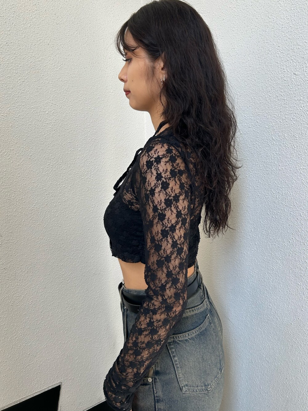 ブラック系のTシャツ/カットソー、ブラック系のキャミソール、ブルー系のデニムパンツを着用したレディースの秋コーディネートの5枚目の写真