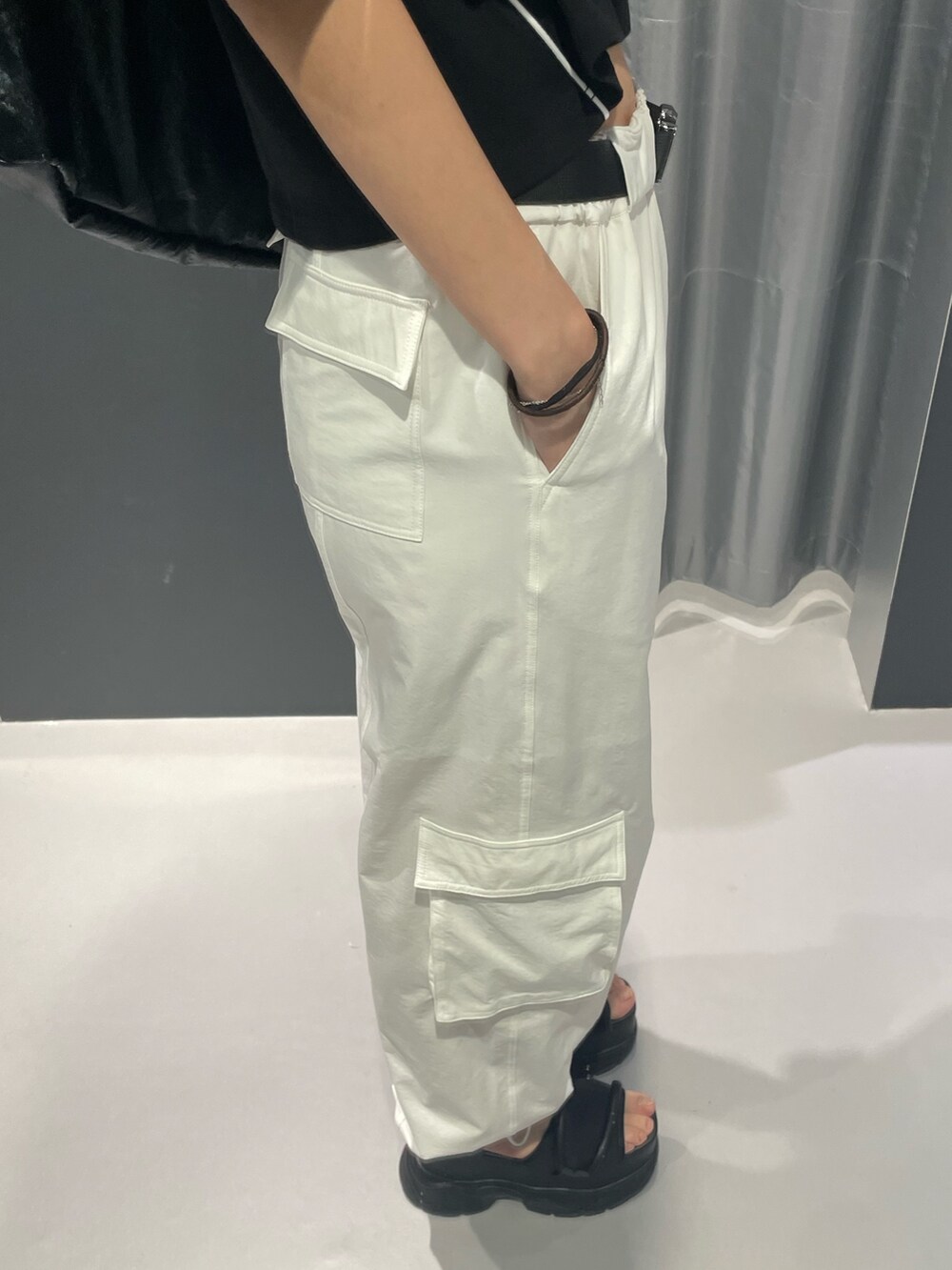 ブラック系のTシャツ/カットソー、ブラック系のハンドバッグ、ホワイト系のカーゴパンツを着用したレディースの春コーディネートの7枚目の写真