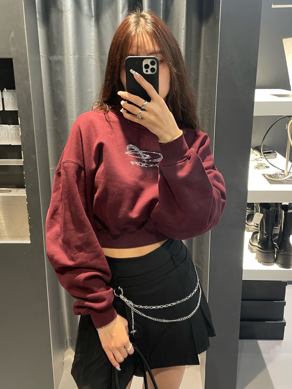 レッド系のTシャツ/カットソー、ブラック系のブルゾン、ブラック系のスカートを着用したレディースの冬コーディネートの6枚目の写真