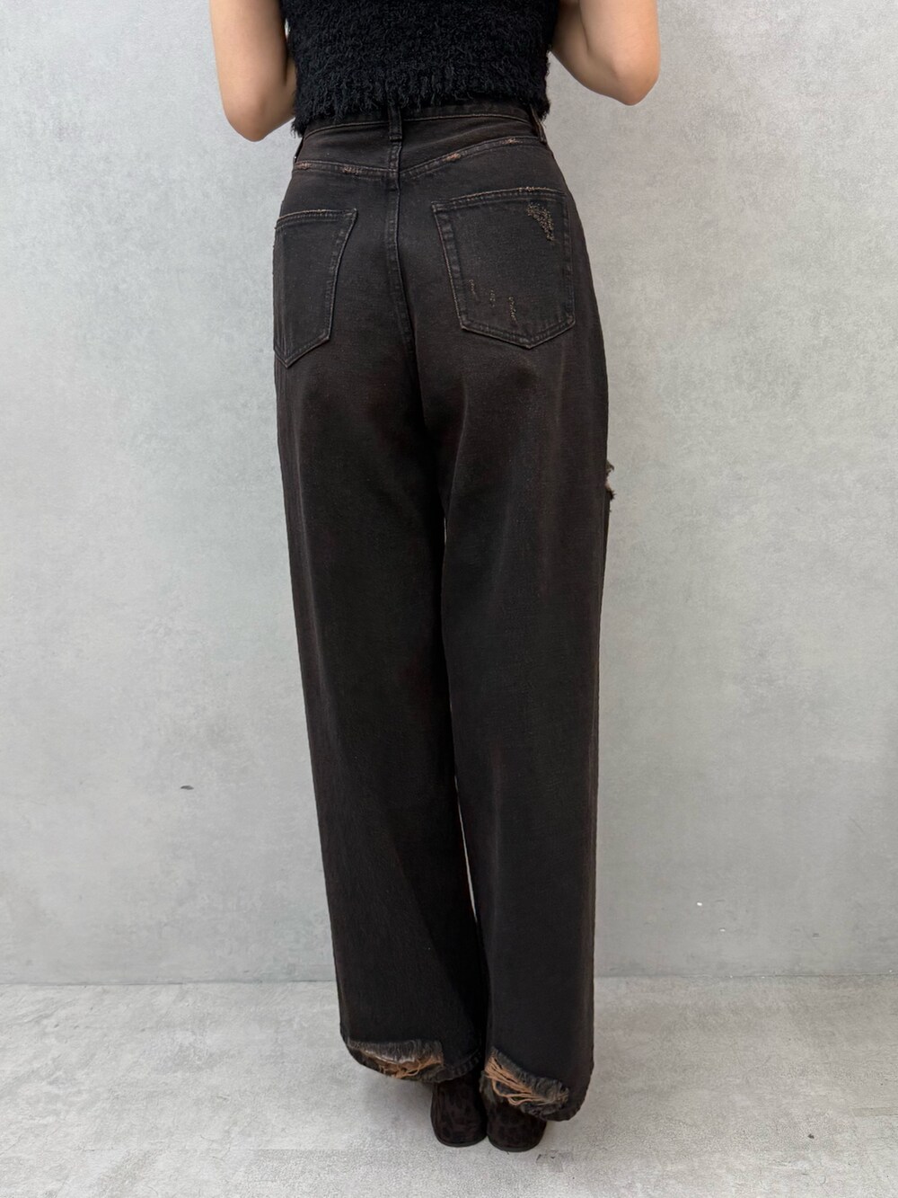 ブラック系のニット/セーター、ブラック系のデニムパンツ、ブラウン系のサンダルを着用したレディースの夏コーディネートの9枚目の写真