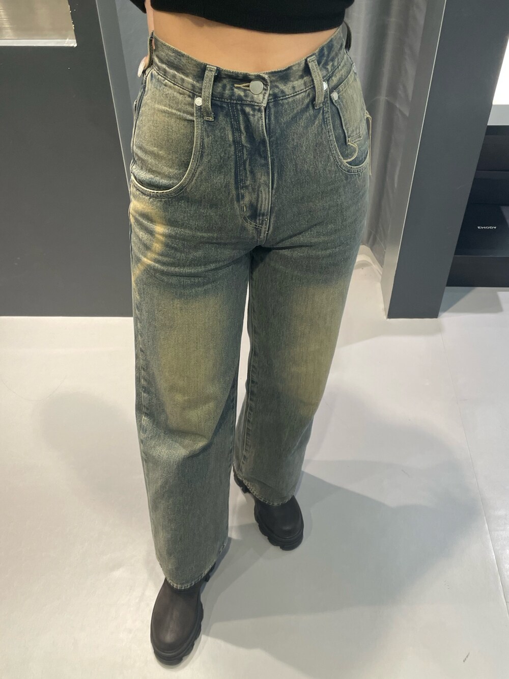 ブラック系のニット/セーター、ブルー系のデニムパンツ、ブラック系のブーツを着用したレディースの冬コーディネートの7枚目の写真