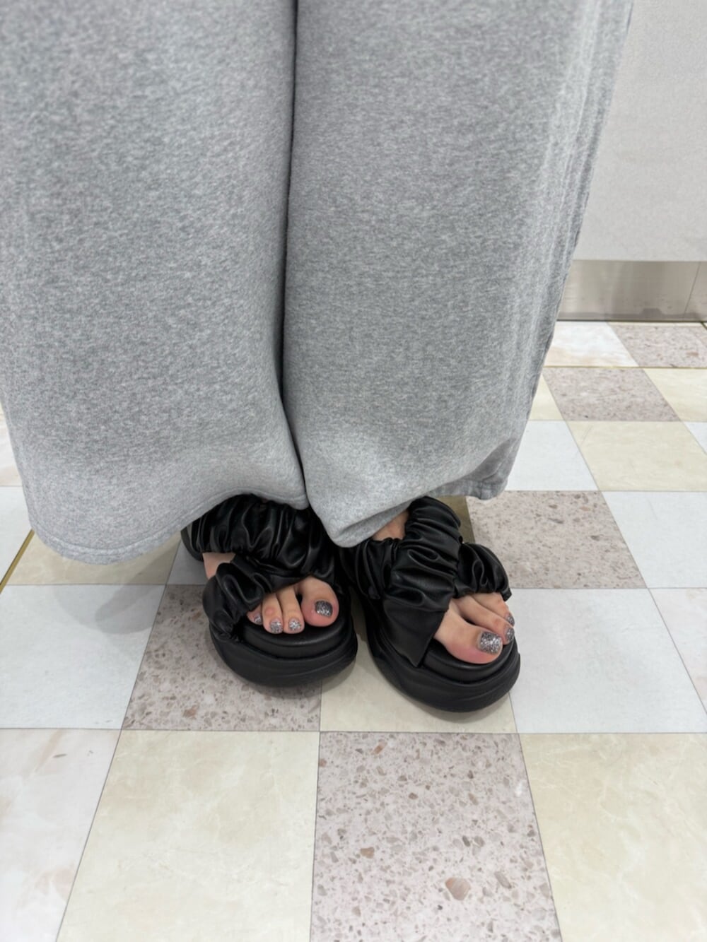 ブラック系のサンダル、その他のタンクトップ、グレー系のスウェットパンツを着用したレディースの夏コーディネートの6枚目の写真