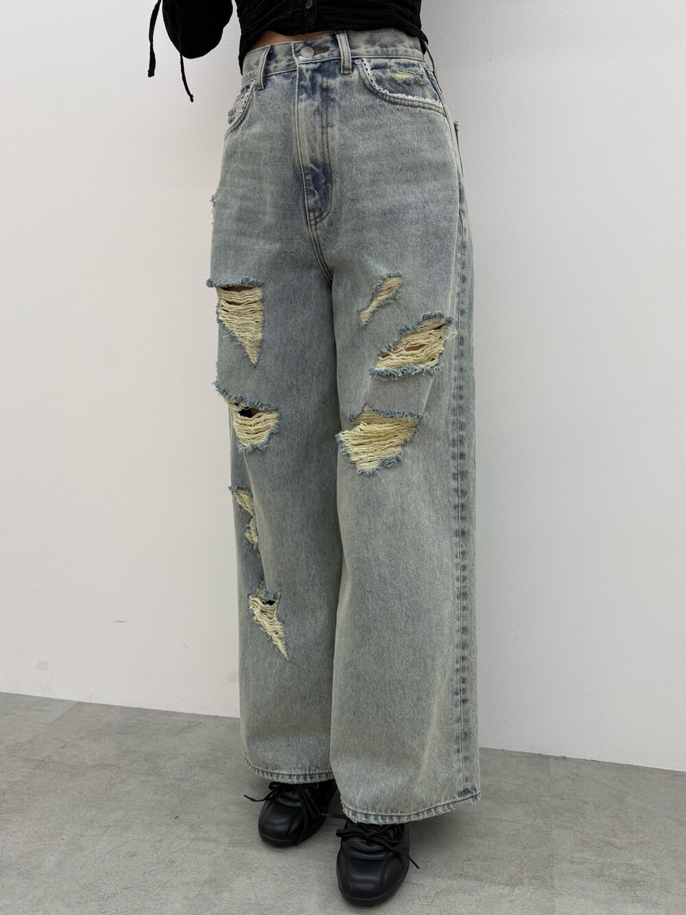 ブラック系のTシャツ/カットソー、ブルー系のデニムパンツ、ブラック系のスニーカーを着用したレディースの冬コーディネートの4枚目の写真