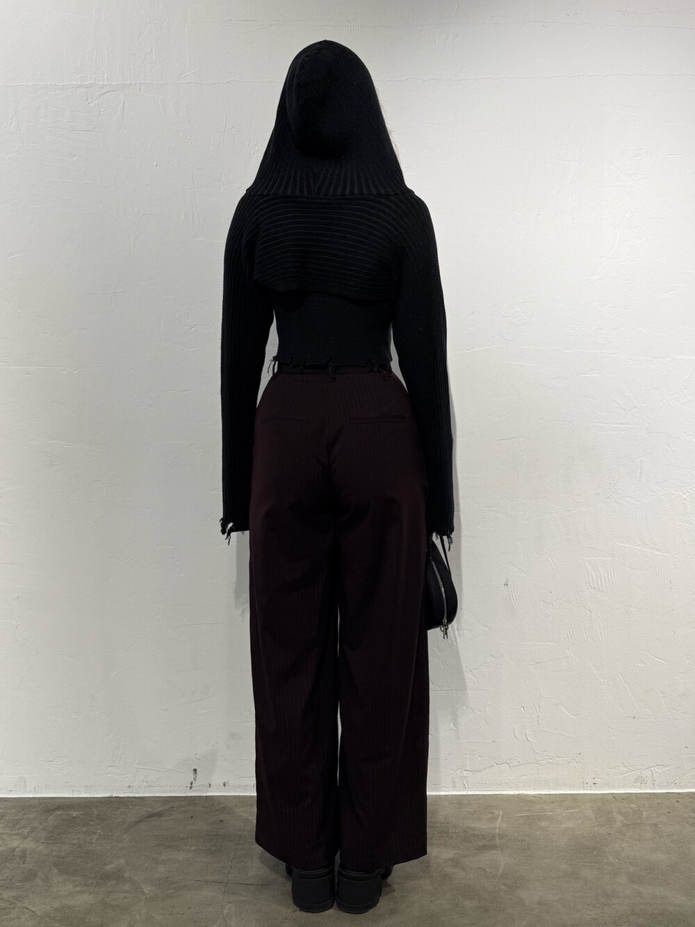 ブラック系のニット/セーター、ブラウン系のその他パンツ、ブラック系のハンドバッグを着用したレディースの秋コーディネートの3枚目の写真