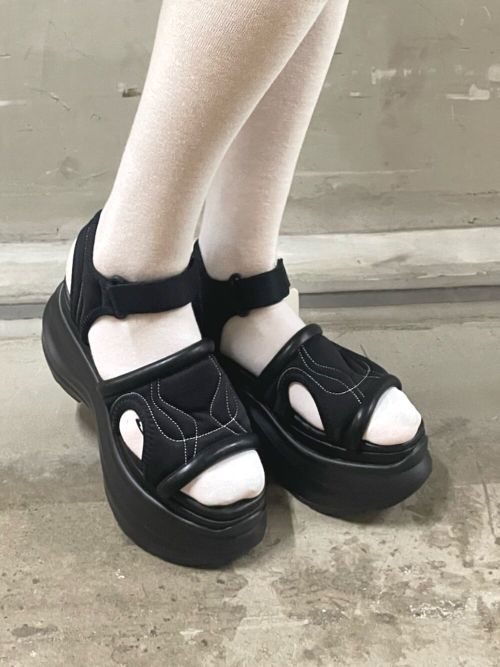 ブラック系のTシャツ/カットソー、グレー系のその他パンツ、ブラック系のサンダルを着用したレディースの春コーディネートの9枚目の写真