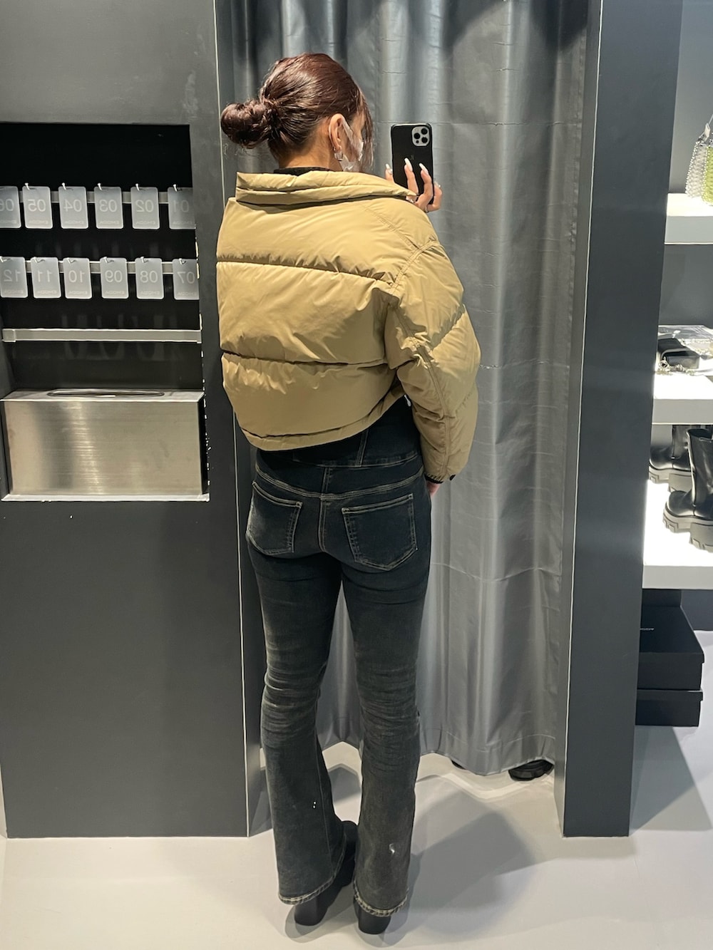 ブラック系のニット/セーター、ベージュ系のブルゾン、ブルー系のデニムパンツを着用したレディースの冬コーディネートの3枚目の写真