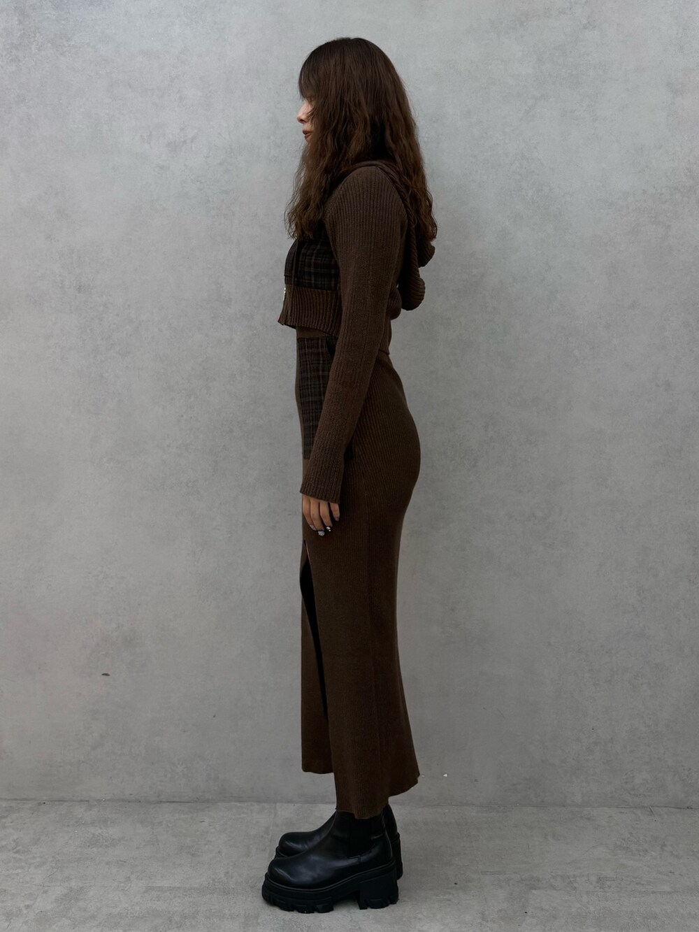 グリーン系のニット/セーター、グリーン系のワンピース、ブラック系のブーツを着用したレディースの秋コーディネートの2枚目の写真