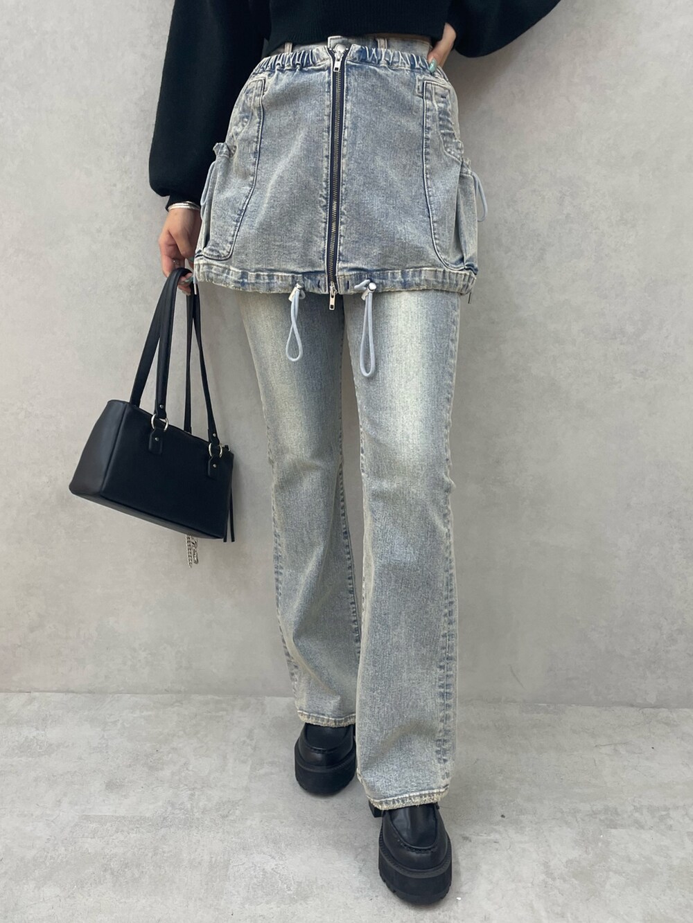 ホワイト系のニット/セーター、ブルー系のデニムパンツ、ブラック系のローファーを着用したレディースの夏コーディネートの6枚目の写真