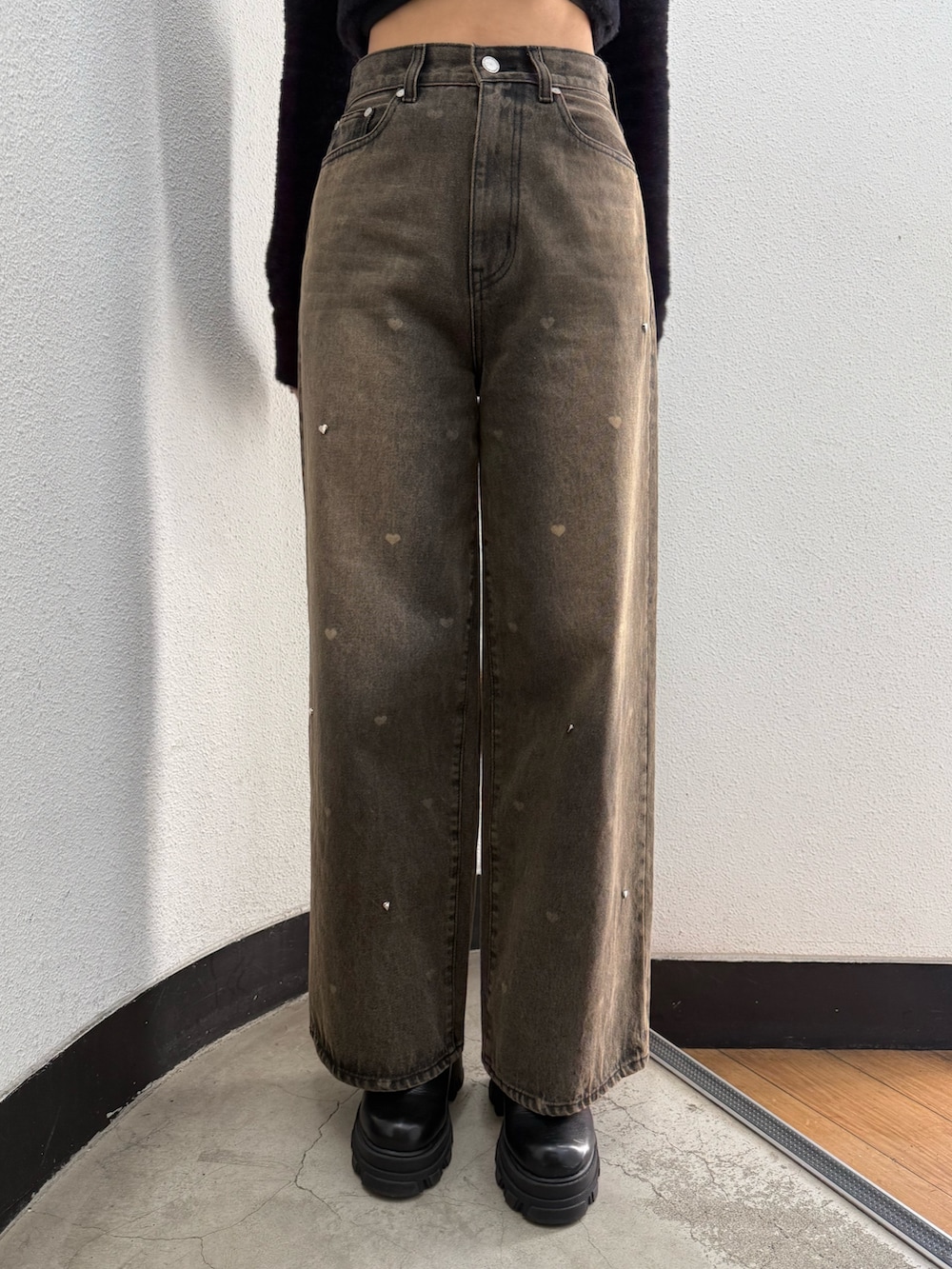 ブラック系のTシャツ/カットソー、ブラウン系のデニムパンツ、ブラック系のブーツを着用したレディースの秋コーディネートの6枚目の写真