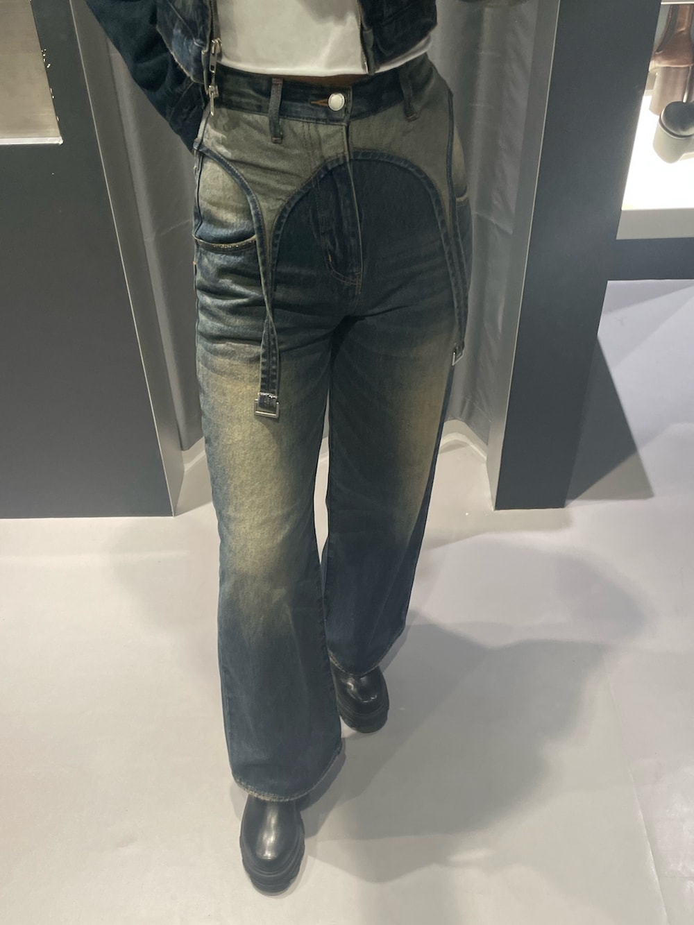 レッド系のニット/セーター、ブルー系のデニムパンツ、ブラック系のハンドバッグを着用したレディースの秋コーディネートの6枚目の写真