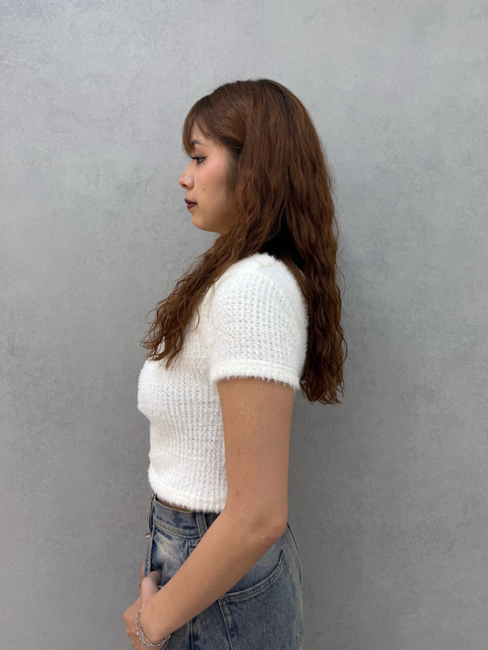 ホワイト系のTシャツ/カットソー、ブルー系のデニムパンツ、ブラック系のブーツを着用したレディースの夏コーディネートの5枚目の写真