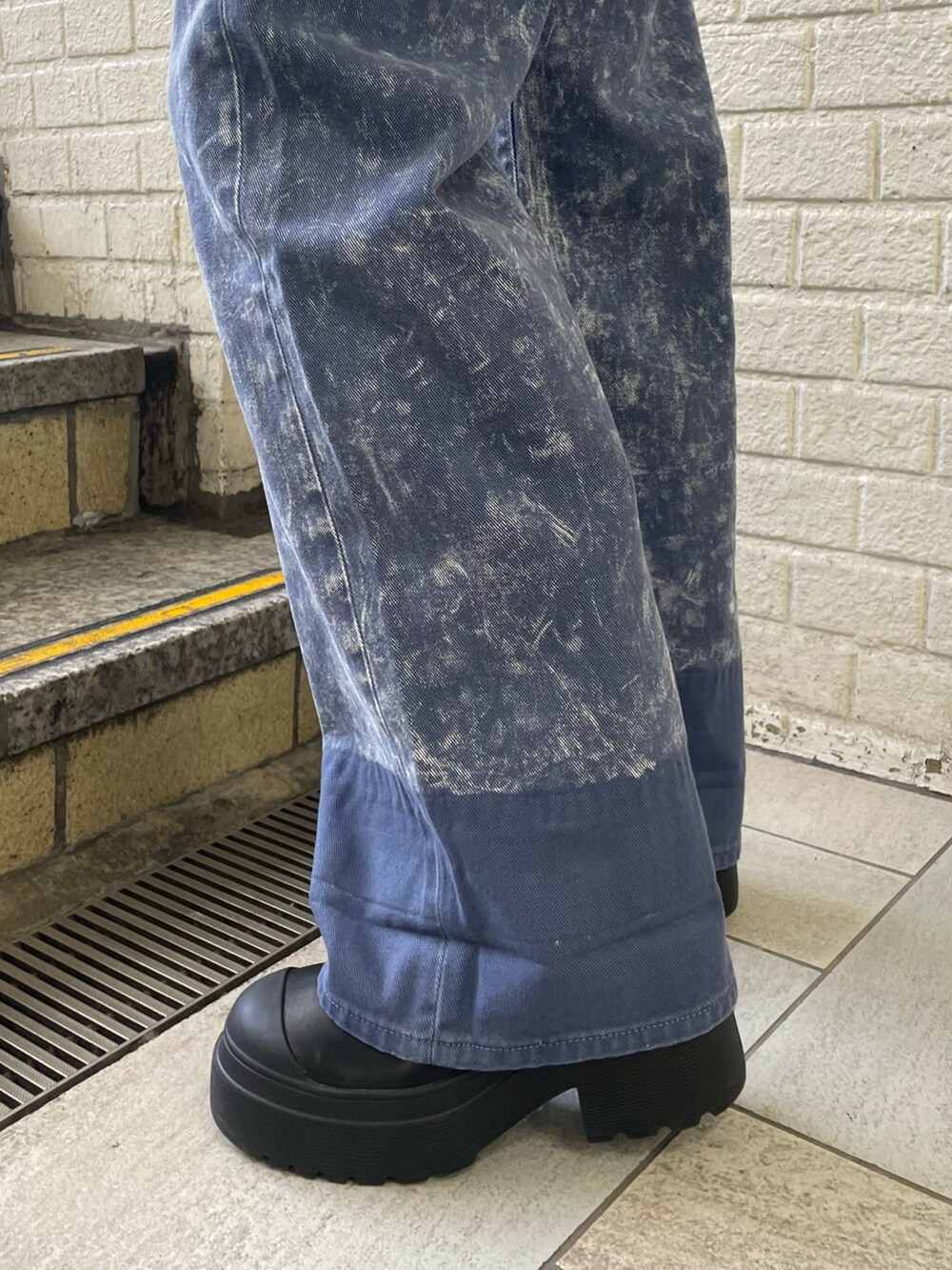 ブラック系のニット/セーター、パープル系のデニムパンツ、ブラック系のブーツを着用したレディースの秋コーディネートの9枚目の写真