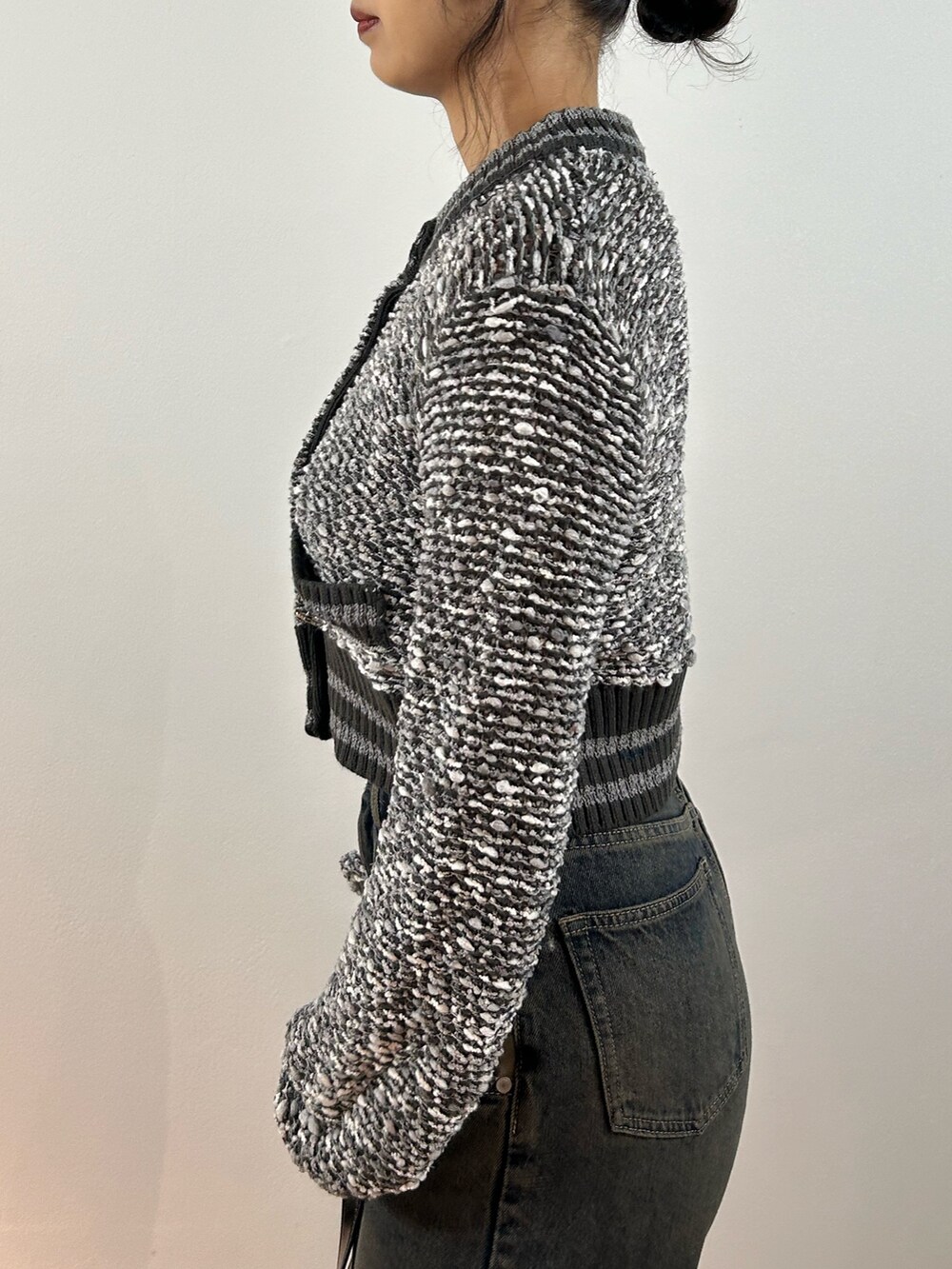 グレー系のカーディガン/ボレロ、ブルー系のデニムパンツ、ブラック系のショルダーバッグを着用したレディースの秋コーディネートの5枚目の写真