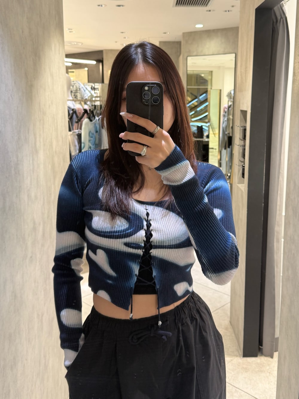 ブラック系のスニーカー、ブラック系のその他パンツ、ブルー系のニット/セーターを着用したレディースの春コーディネートの4枚目の写真