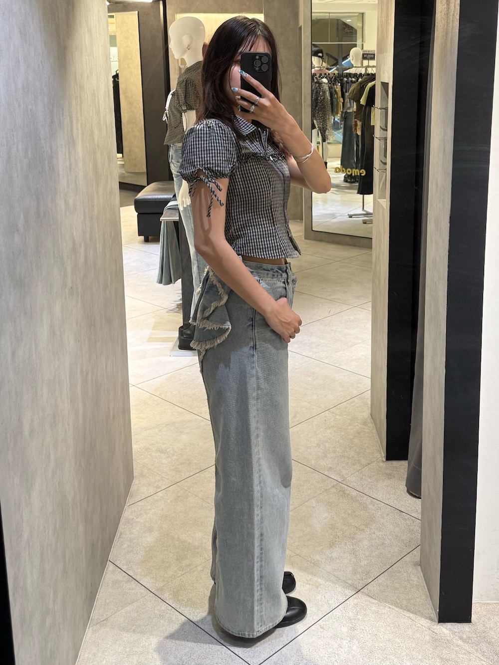ブラック系のシャツ/ブラウス、ブルー系のデニムパンツ、ブラック系のスニーカーを着用したレディースの春コーディネートの2枚目の写真