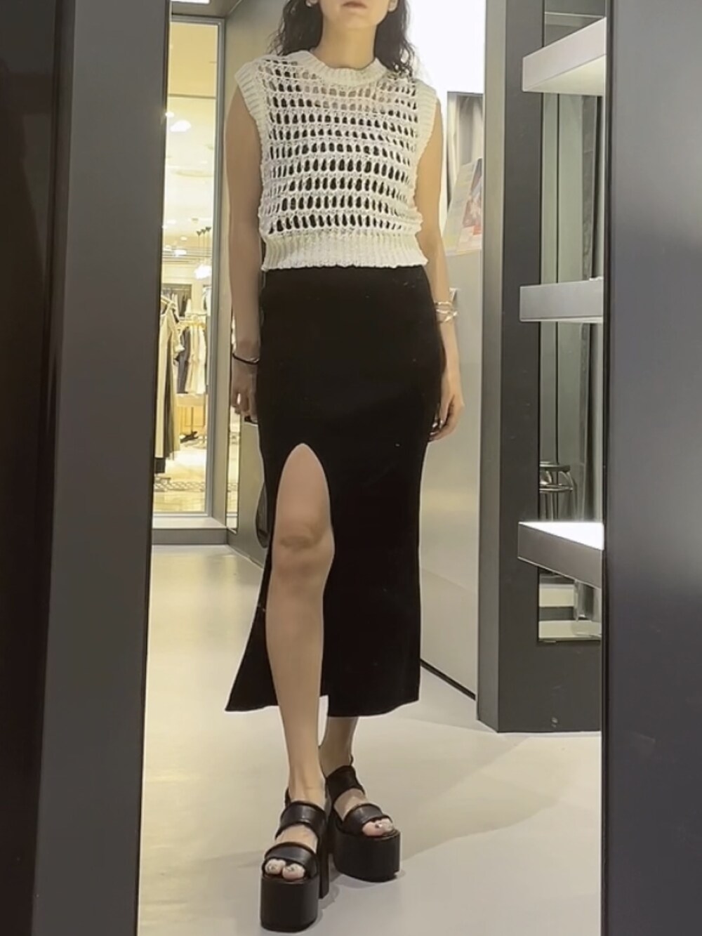 ホワイト系のタンクトップ、ブラック系のワンピース、ブラック系のサンダルを着用したレディースの夏コーディネートの3枚目の写真