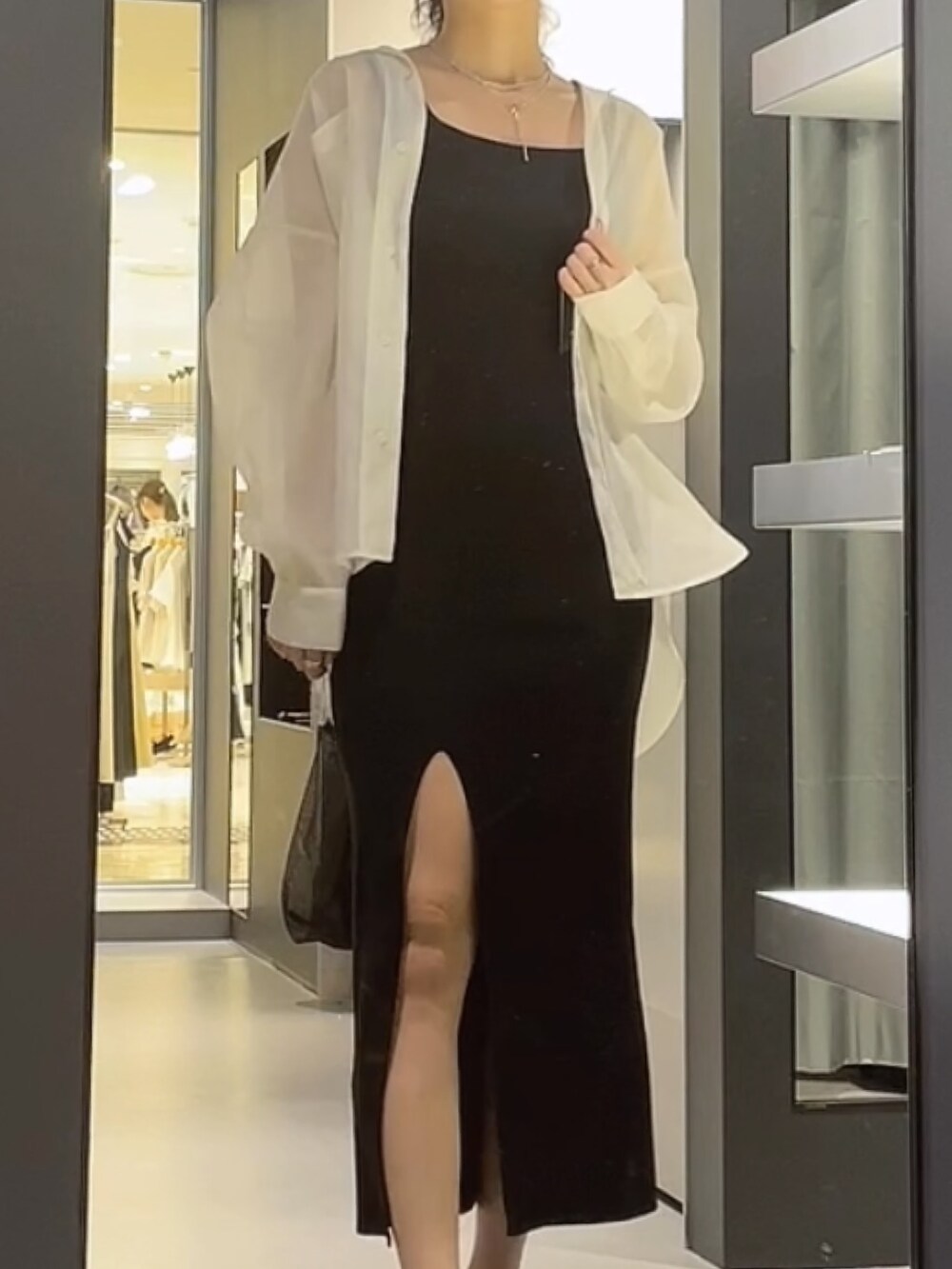 ブラック系のハンドバッグ、ホワイト系のシャツ/ブラウス、ブラック系のワンピースを着用したレディースの夏コーディネートの3枚目の写真