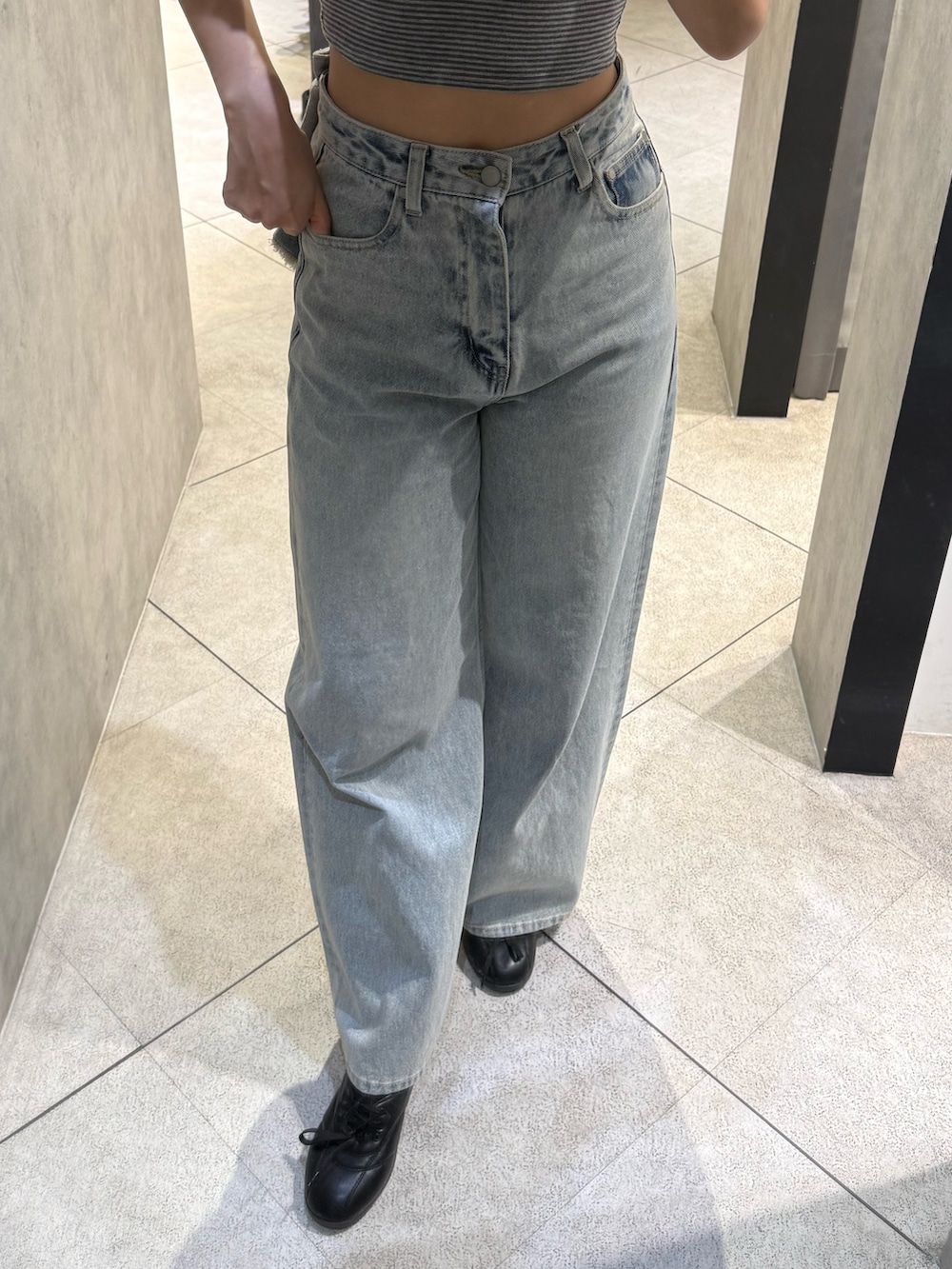 グレー系のTシャツ/カットソー、ブルー系のデニムパンツ、ブラック系のスニーカーを着用したレディースの春コーディネートの5枚目の写真