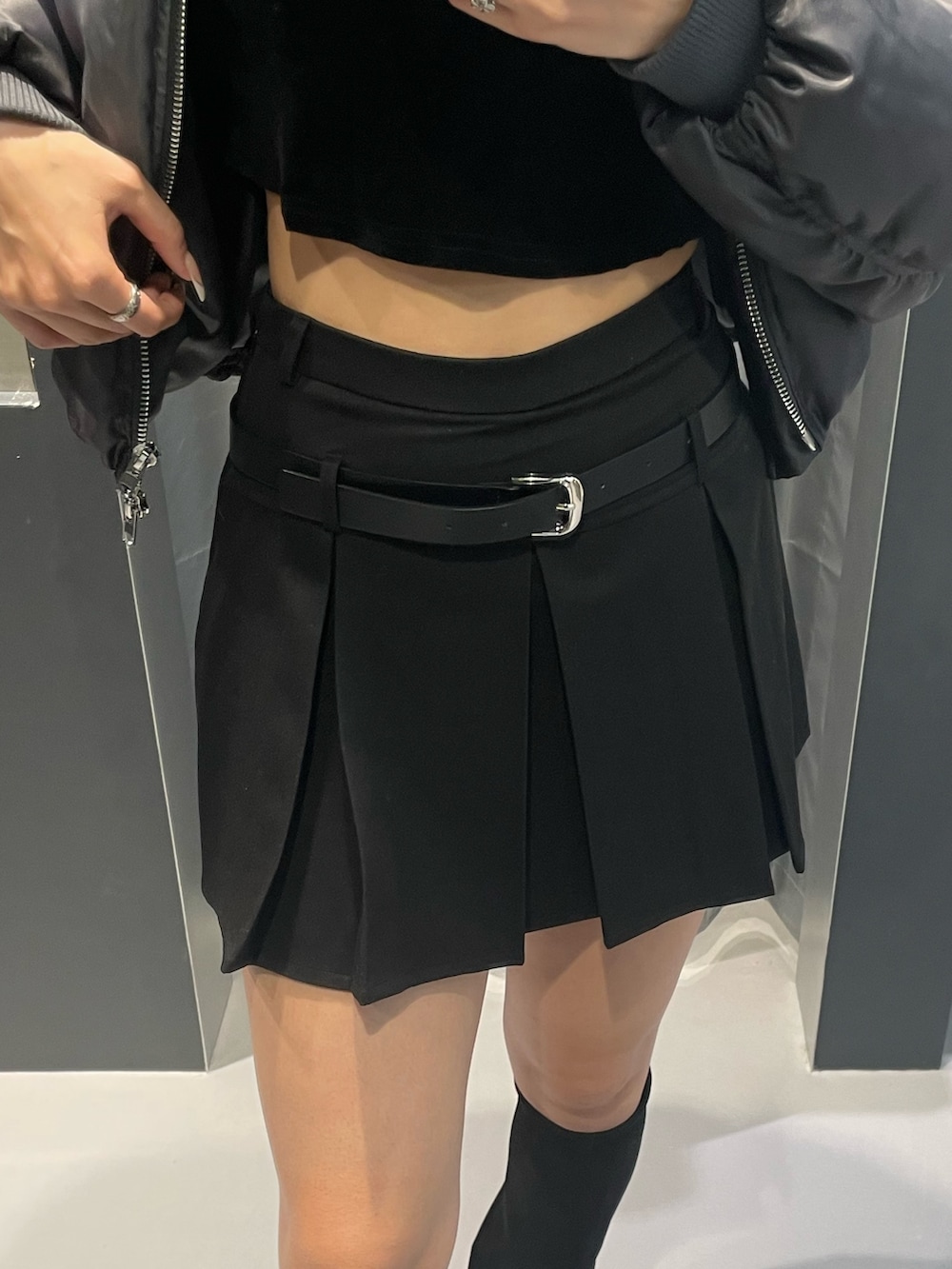 グレー系のニット/セーター、ブラック系のスカート、ブラック系のブーツを着用したレディースの秋コーディネートの6枚目の写真