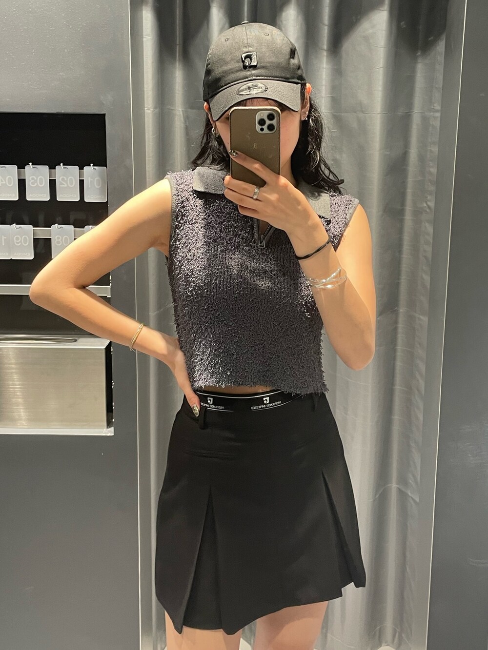 グレー系のタンクトップ、ブラック系のスカート、ブラック系のサンダルを着用したレディースの夏コーディネートの4枚目の写真