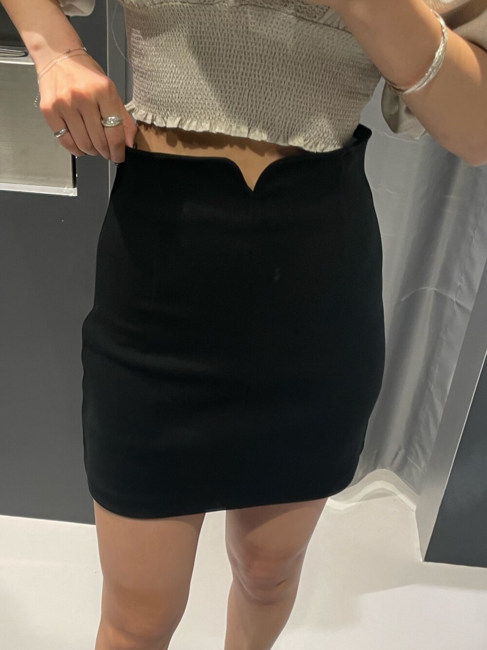 ベージュ系のTシャツ/カットソー、ブラック系のスカート、ブラック系のサンダルを着用したレディースの夏コーディネートの7枚目の写真