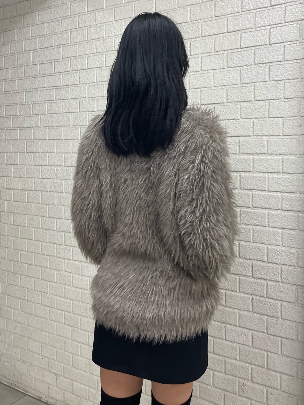 グレー系のカーディガン/ボレロ、ホワイト系のTシャツ/カットソー、ブラック系のスカートを着用したレディースの秋コーディネートの6枚目の写真