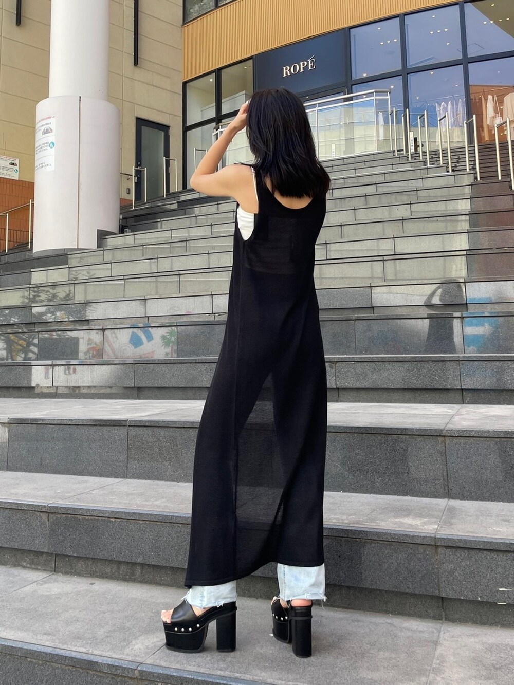 ホワイト系のTシャツ/カットソー、ブラック系のカーディガン/ボレロ、ブルー系のデニムパンツを着用したレディースの夏コーディネートの3枚目の写真