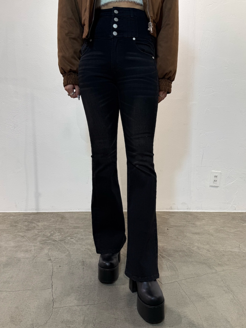 レッド系のニット/セーター、ブラック系のデニムパンツ、ブラック系のブーツを着用したレディースの冬コーディネートの6枚目の写真