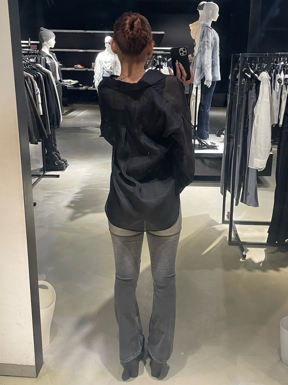 ブラック系のニット/セーター、ブラック系のシャツ/ブラウス、ブラック系のデニムパンツを着用したレディースの春コーディネートの3枚目の写真