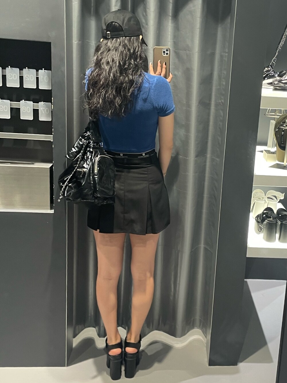 ブルー系のTシャツ/カットソー、ブラック系のハンドバッグ、ブラック系のスカートを着用したレディースの夏コーディネートの3枚目の写真