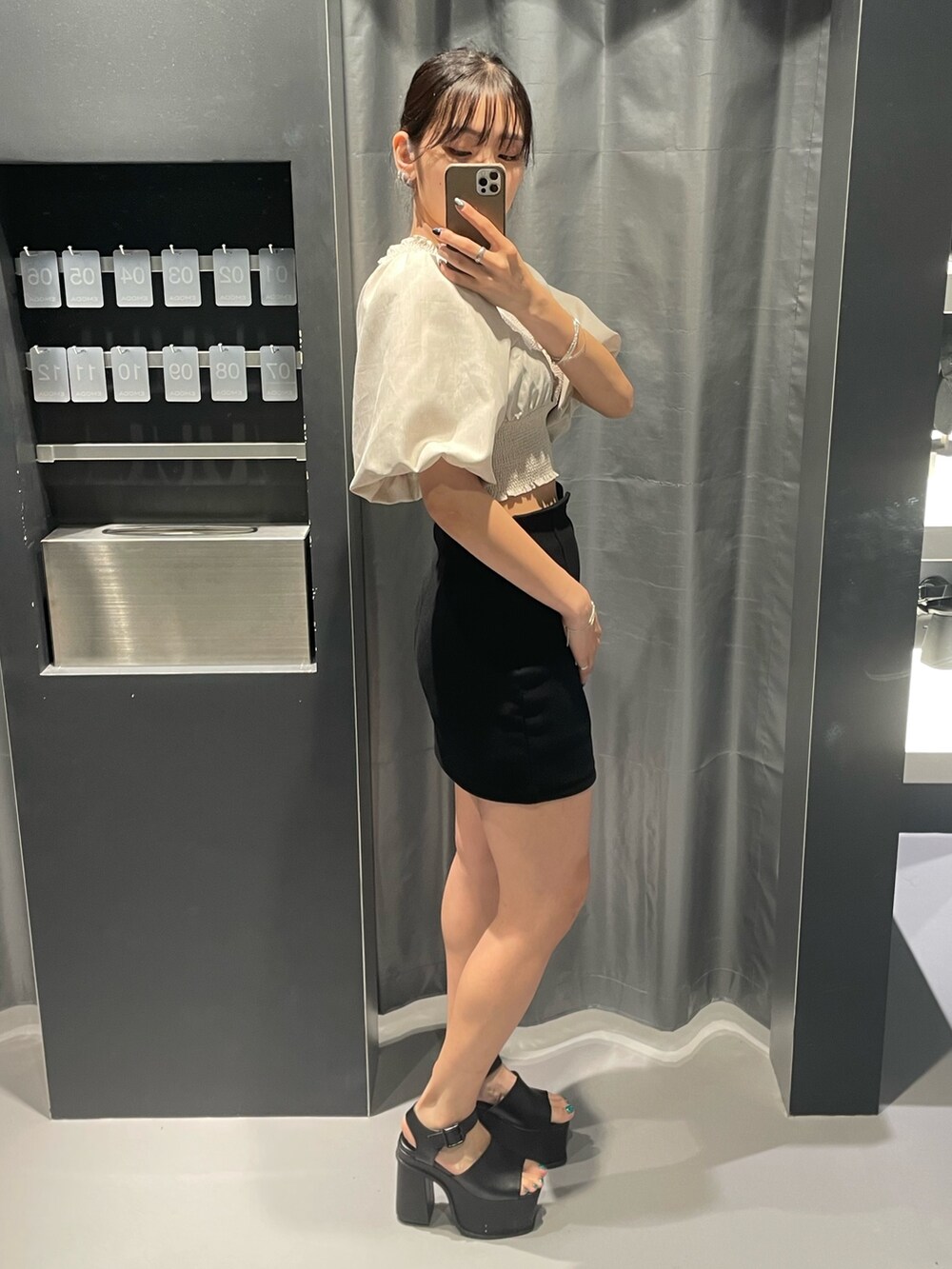 ベージュ系のTシャツ/カットソー、ブラック系のスカート、ブラック系のサンダルを着用したレディースの夏コーディネートの2枚目の写真